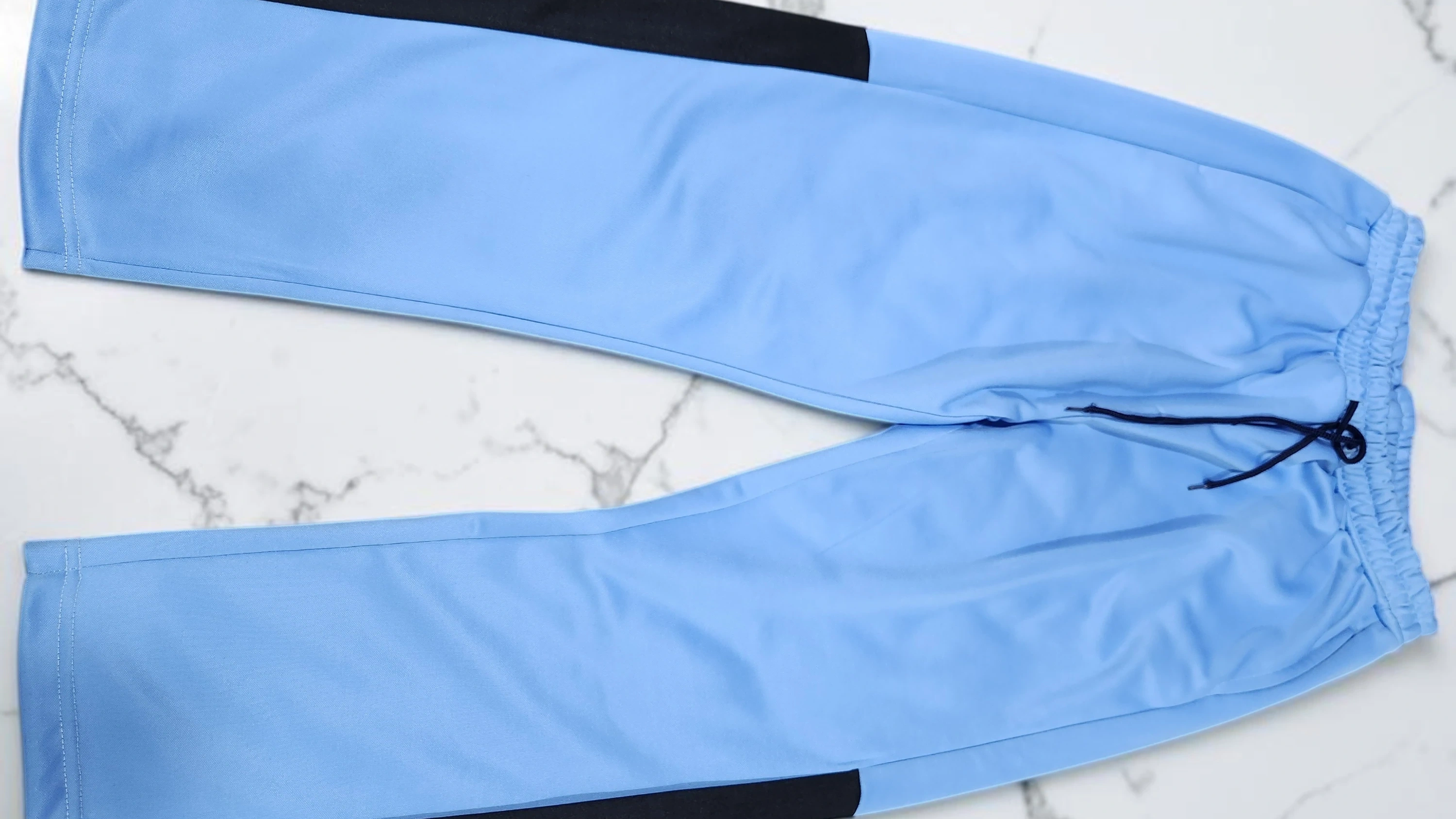 100% polyester track trousers in sky blue with black contrast panels and drawstring waist